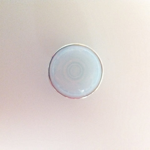 Clear opal stone that throws blue and pink colour with thin silver surround 18 mm snap (colour of stone will vary)