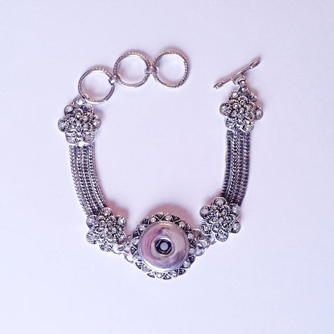 Silver coloured bracelet with rhinestone surround and metal flowers for 18 mm snap
