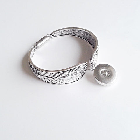 Silver coloured thick bangle with peacock feather design and magnetic clasp for 18 mm snap